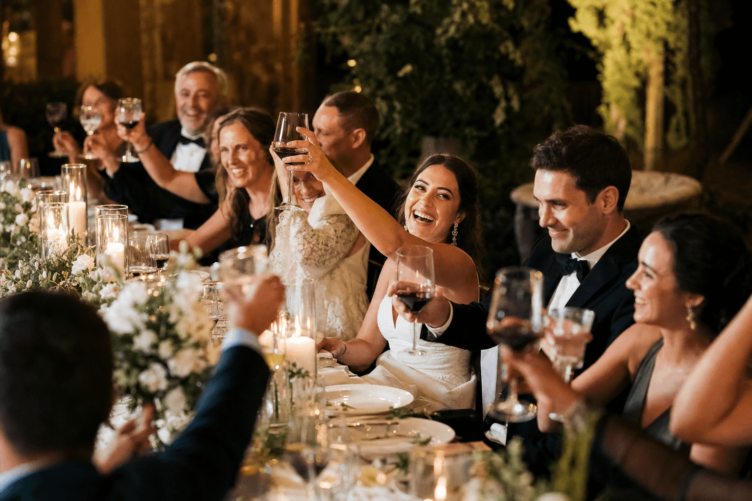 Bruidspaar en gasten proosten tijdens het diner